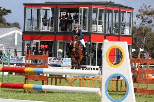 Tiffany and LH Folly jumping and the red VIP area in the background